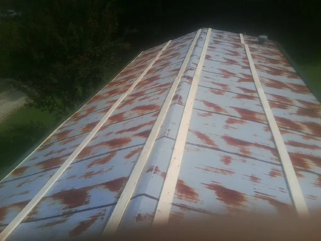 Rusted metal roof panels with new wood purlins before replacement — Storm Damage Roof Repair in Englewood by Roofing Brothers