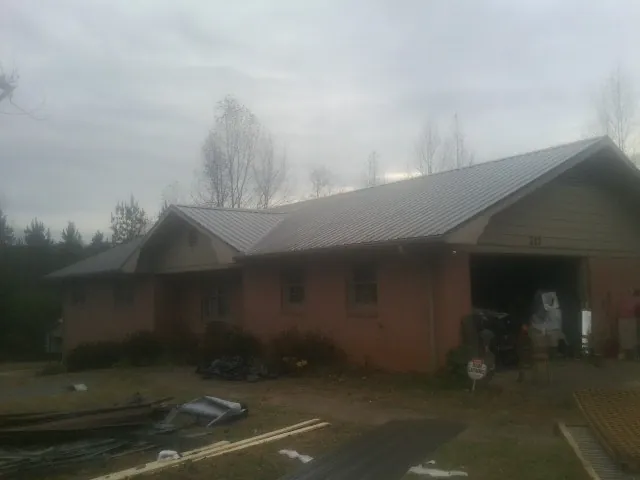 Gray metal roof on a stucco house with an attached garage in Englewood